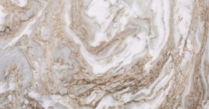 A large slab of brown and white veined quartzite up close. Swirls and swaths of gray coloring add to the pattern.